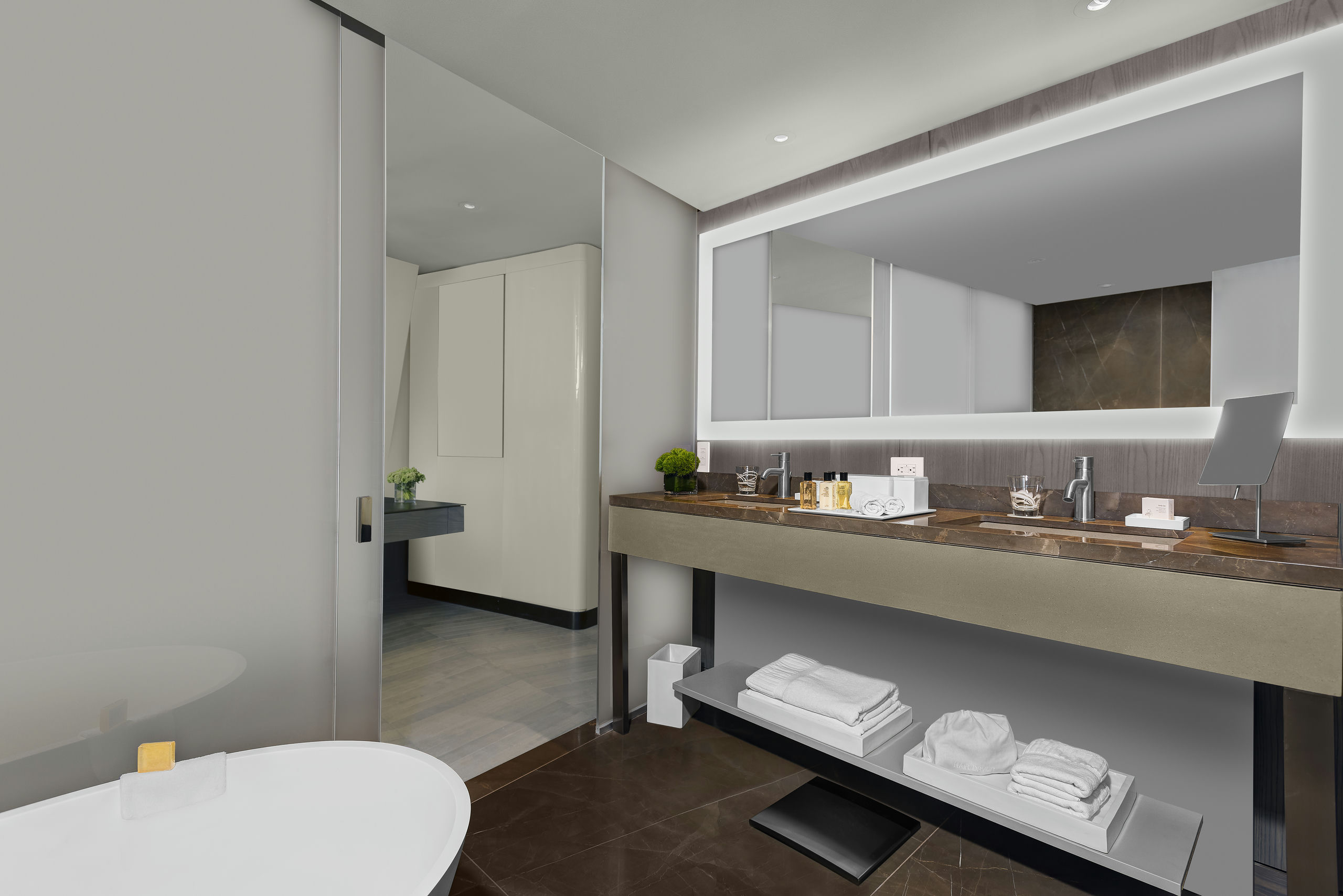 A modern bathroom with a double sink, large mirror, and tiled floor.