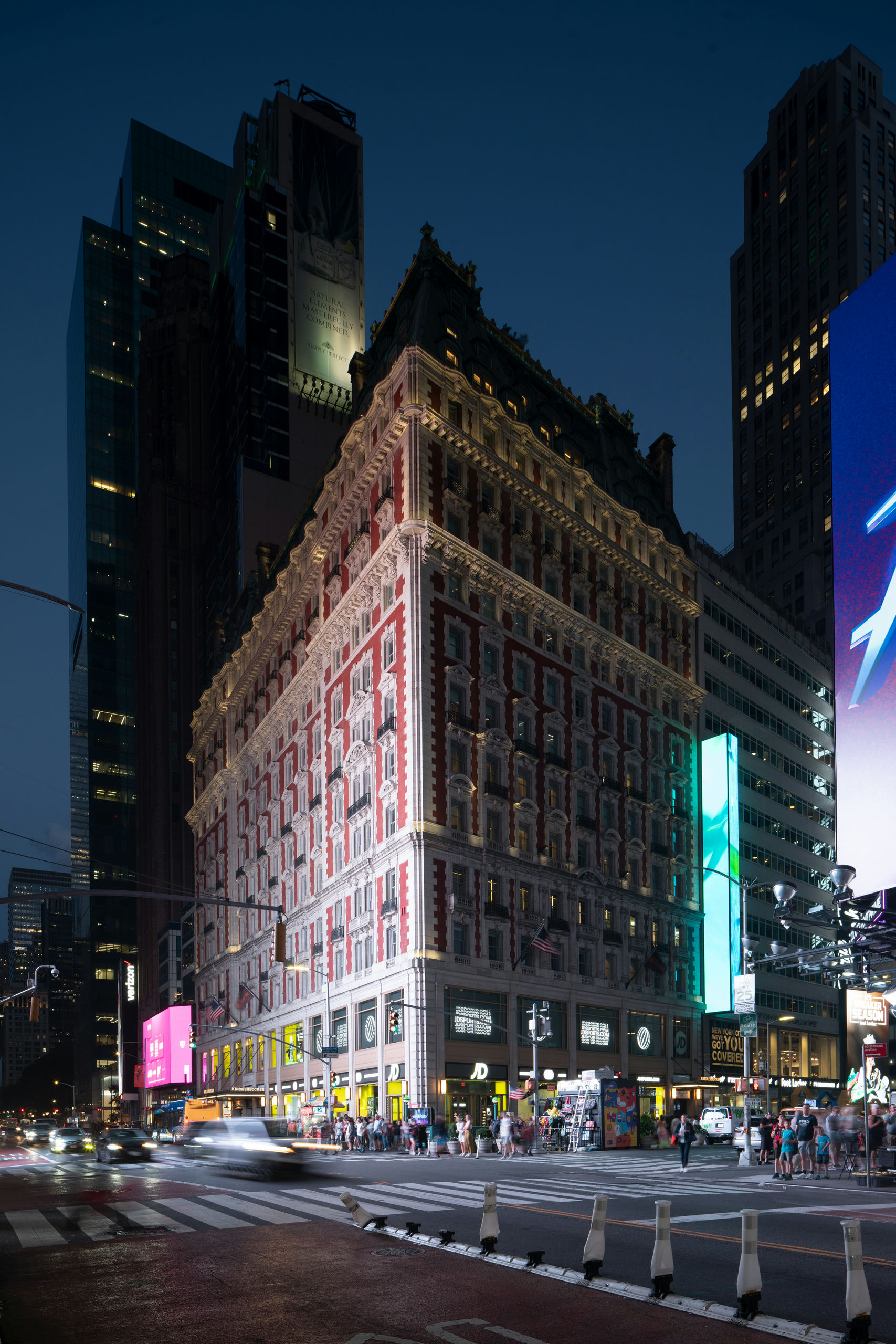 A lit-up building with ornate facade in a city at night