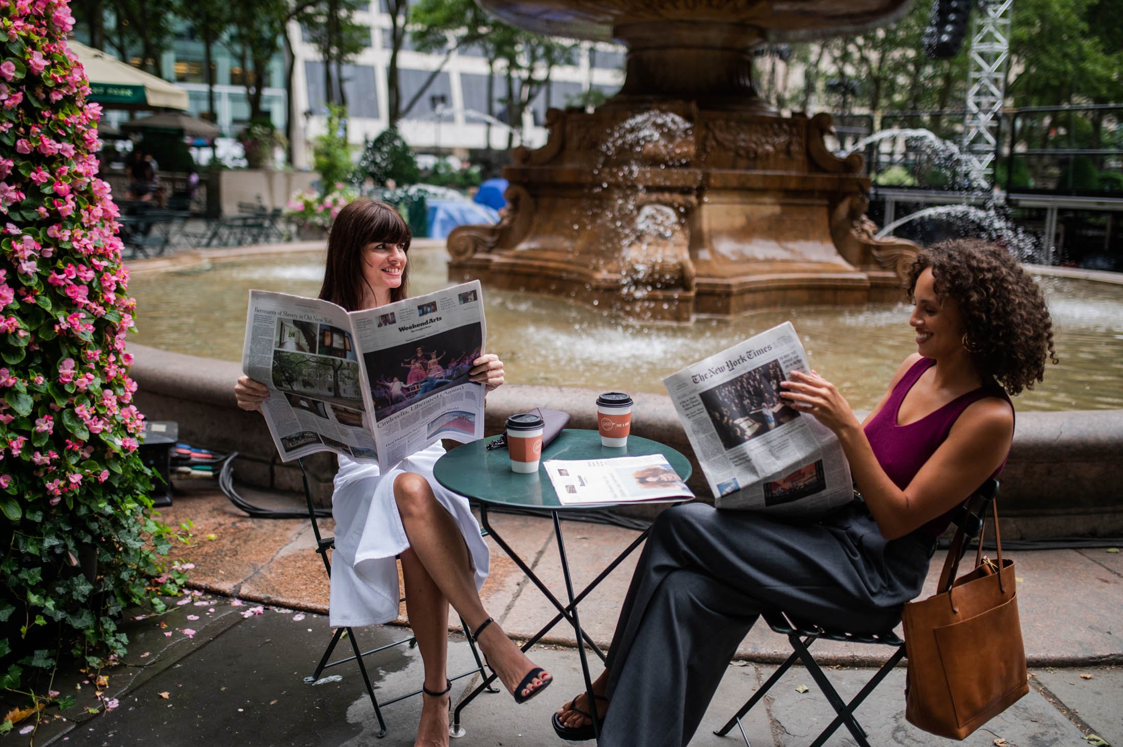 women reading newspapers at park