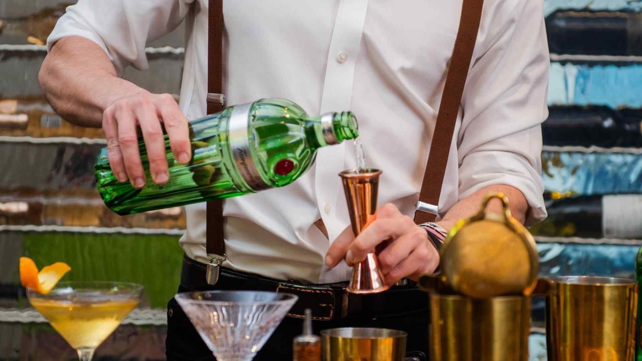 A bartender pouring a drink into a jigger.